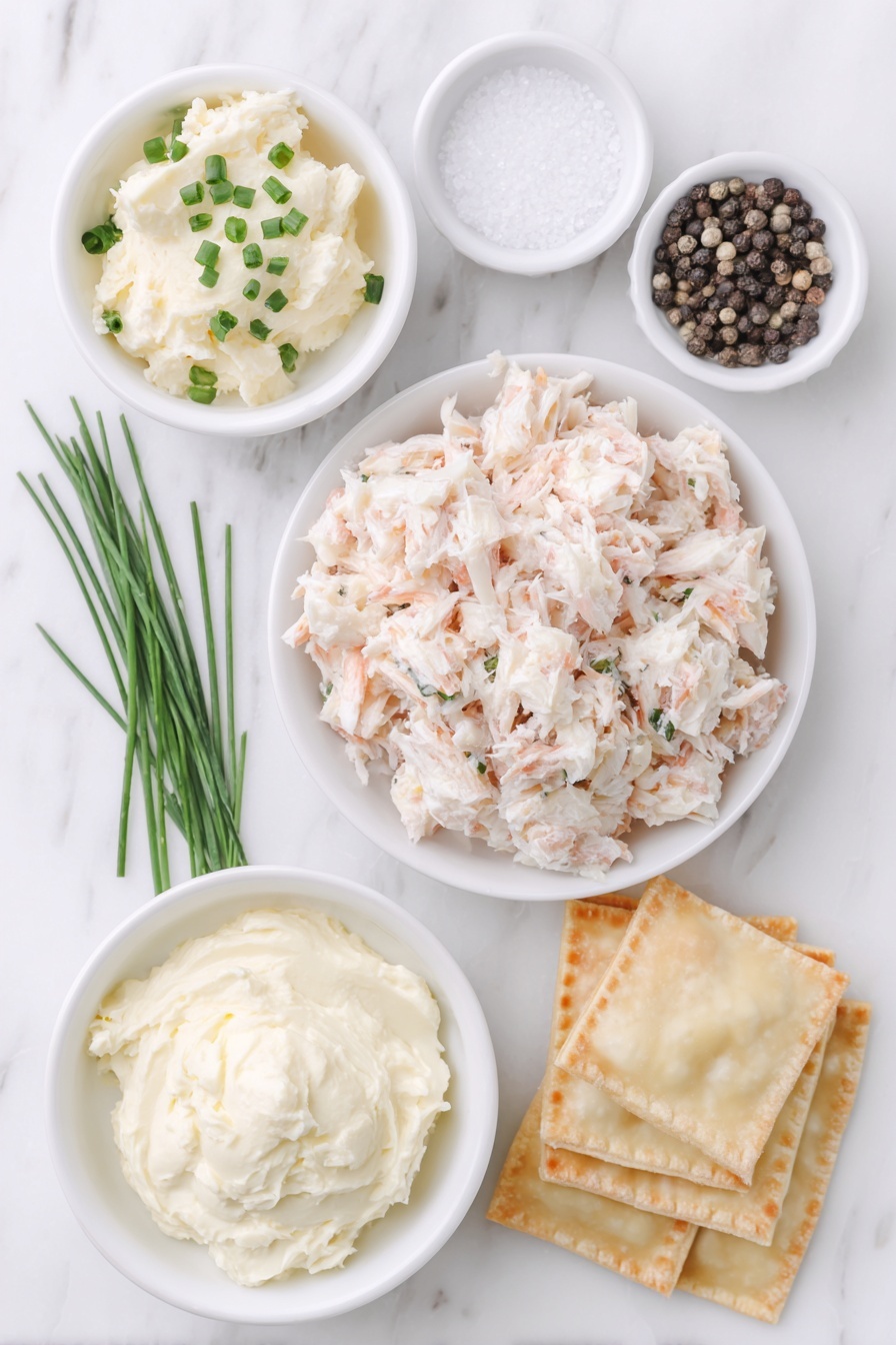 Flat lay of fresh lump crab meat, a small bowl of softened cream cheese, a few chopped green chive sprigs, a small white bowl with kosher salt, a small white bowl with whole black peppercorns, a neat stack of square wonton wrappers, and a small white bowl of clear water, arranged symmetrically around a simple white ceramic plate on a clean white marble surface, soft natural light, photo taken with an iPhone, professional food photography style, fresh ingredients, white ceramic bowls, no bottles, no duplicates, no utensils, no packaging --ar 2:3 --v 7 --p m7354615311229779997